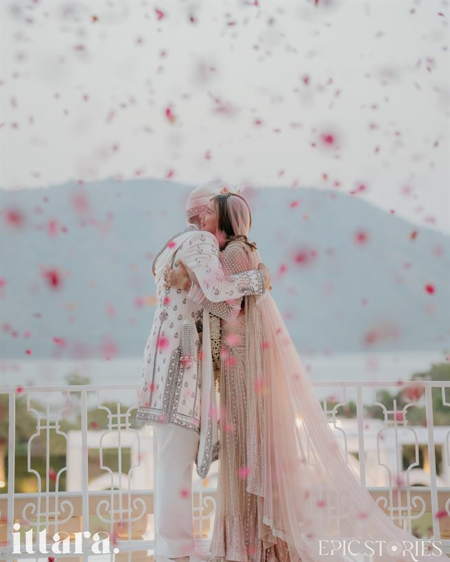 A couple amid falling petals at an Ittara-designed wedding